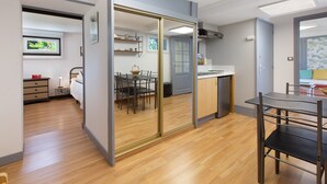 Cuina moderna amb zona de menjador, terres de fusta i un gran mirall.