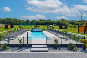 A swimming pool with a sun deck, surrounded by lounge chairs and potted plants. - Holiday homes with access to the SPA area (Kopan)