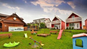 Ein Spielplatz mit Schaukeln, Rutschen und einer Wippe.