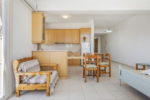 Ein gemütlicher Wohnbereich mit Küchenzeile, Essplatz, Sofa und Bett.
