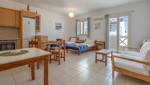 A compact living space with a kitchenette, a dining area, a bed, and a sofa. - Apartment 'Maria Suite 2' with Sea View, Wi-Fi and Air Conditioning (Mirtos)
