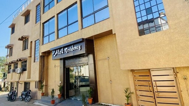 Un immeuble sur lequel on peut lire l’inscription « Alok Residency », doté de nombreuses fenêtres et d’une entrée fermée par un portail.