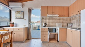 Cucina con mobili in legno, forno a microonde e macchina del caffè.