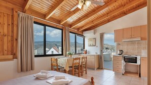 Una stanza con un letto, un tavolo da pranzo, sedie, angolo cottura e vista sul paesaggio.