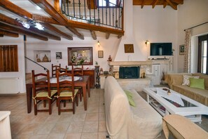 Un salón amplio con chimenea, muebles de madera y un techo alto con vigas a la vista.