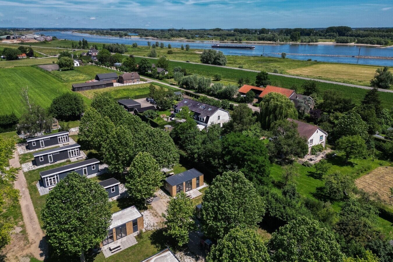 Ett flygbildsbild av ett bostadsområde med hus, en flod och en stor vattenyta i bakgrunden.