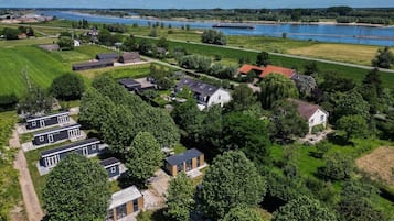 Vue aérienne d’un quartier résidentiel avec des maisons, une rivière et une grande étendue d’eau en arrière-plan.