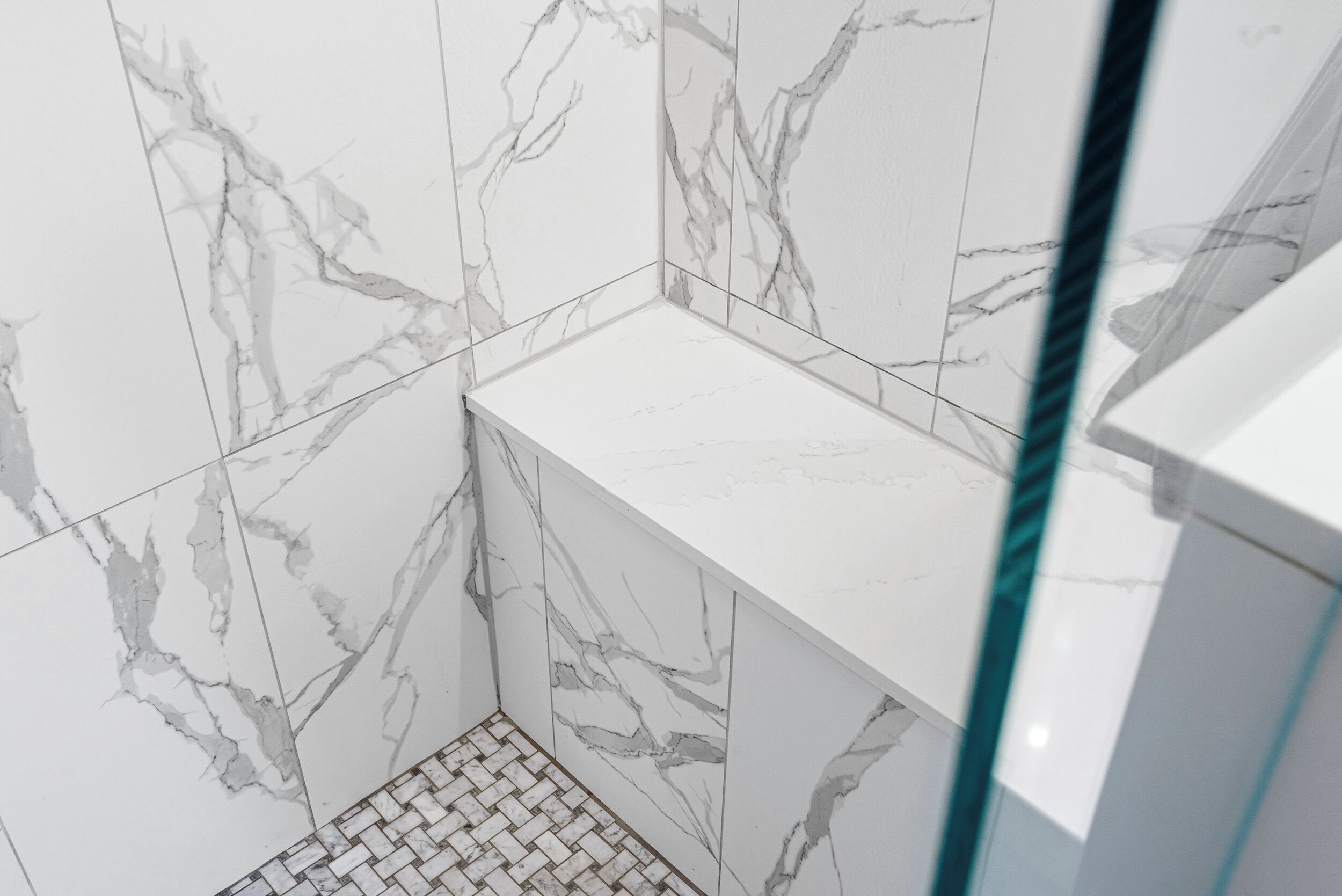 A bathroom with marble walls and a tiled floor.