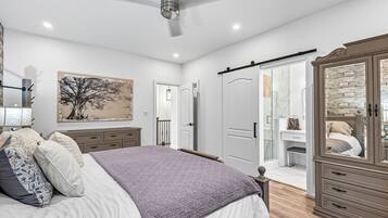 A bedroom with a bed, a wardrobe, a desk, and a painting on the wall.