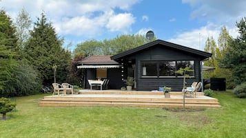 A modern house with a patio, a dining area, and a garage.