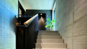 Eine Treppe mit schwarzer Geländer, die zu einem Raum mit einer Pflanze führt.
