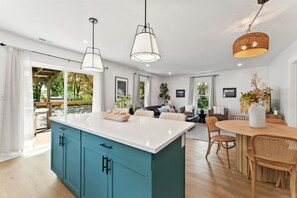 A modern kitchen with a central island, pendant lighting, and a dining area with a round table and chairs. - Blakes Place 2.0 close to Wittenberg (Springfield)