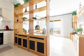 Eine moderne Küche mit Holzschränken, einer eingebauten Kochinsel und Blick zum Essbereich.