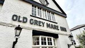 Um edifício com uma placa que diz 'Old Grey Mare Inn'.