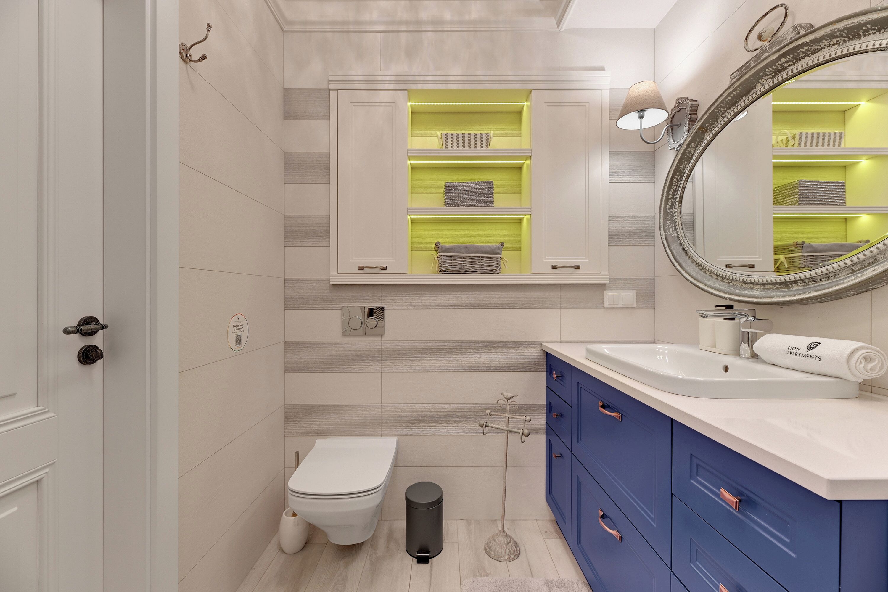 A modern bathroom with a toilet, sink, vanity, and a mirror.