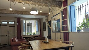 Un comedor con una mesa de madera, sillas y una lámpara colgante.