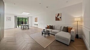 Ein großzügiges Wohnzimmer mit einer Couch, einem Couchtisch und einem Essbereich mit Stühlen und Tisch.