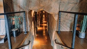 Eine Wendeltreppe mit Steinwänden und Metallgeländern, die zu einer erhöhten Ebene führt.