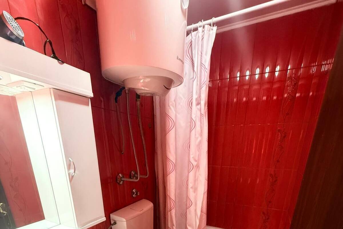A bathroom with a toilet, sink, shower, and bathtub.