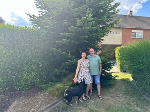 Un quartiere residenziale con una casa, un cane e una persona.