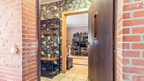A doorway leading to a room with a tiled floor, a brick wall, and a wooden door. - Apartment "Landleben 2" with Shared Terrace, Private Garden, and Wi-Fi (Erkelenz)