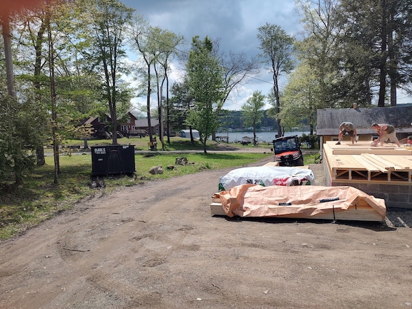 A construction site with wooden planks, a covered area, and a dirt path.