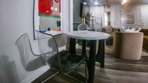 Un salon moderne avec une table ronde, un canapé et un élément décoratif mural.
