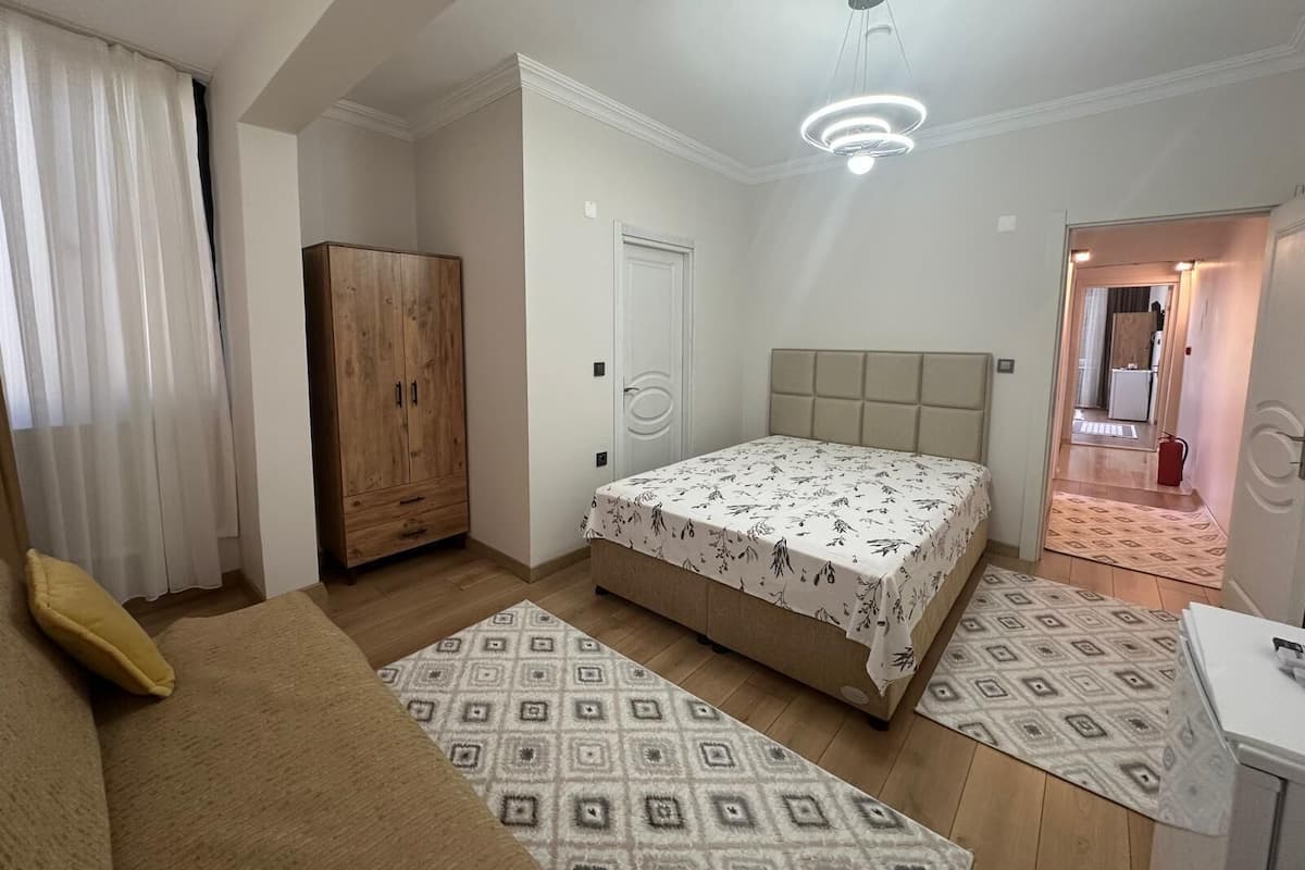 A bedroom with a bed, wardrobe, and a desk.