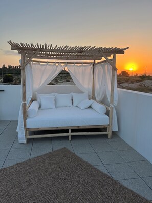 A wooden bed with a canopy, white bedding, and a view of the sunset. - La Casa del Sol de Kirsten heated private pool, jacuzzi in Vistabella Golf (VC)