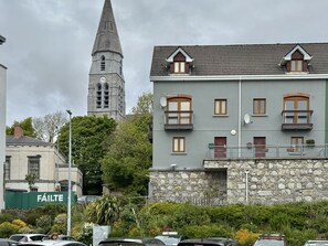 Ein Gebäude mit einer Stein-Fassade, mehreren Fenstern und einem Balkon.