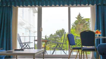 A balcony with a table, chairs, and a remote control.