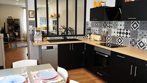 Een moderne keuken met zwarte kastjes, een houten aanrecht, een spoelbak en een vaatwasser.