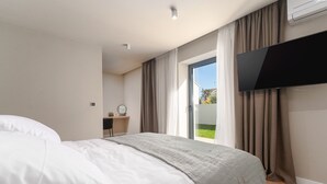 A modern hotel room with a bed, a desk, a television, and a sliding glass door to the outside. - La Residenza Vila apartment I for 6 guest's 1,5 km from sea (Poreč)