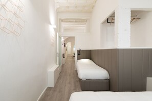 Ein Flur, der in ein Schlafzimmer mit einem Bett, einem Kleiderschrank und einer Kleiderstange führt.