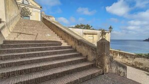Una serie di gradini in pietra che conducono a un edificio con vista sul mare.