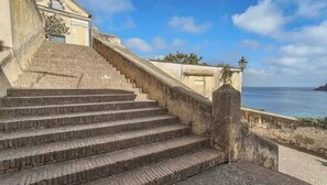 Una serie di gradini in pietra che conducono a un edificio con vista sul mare.