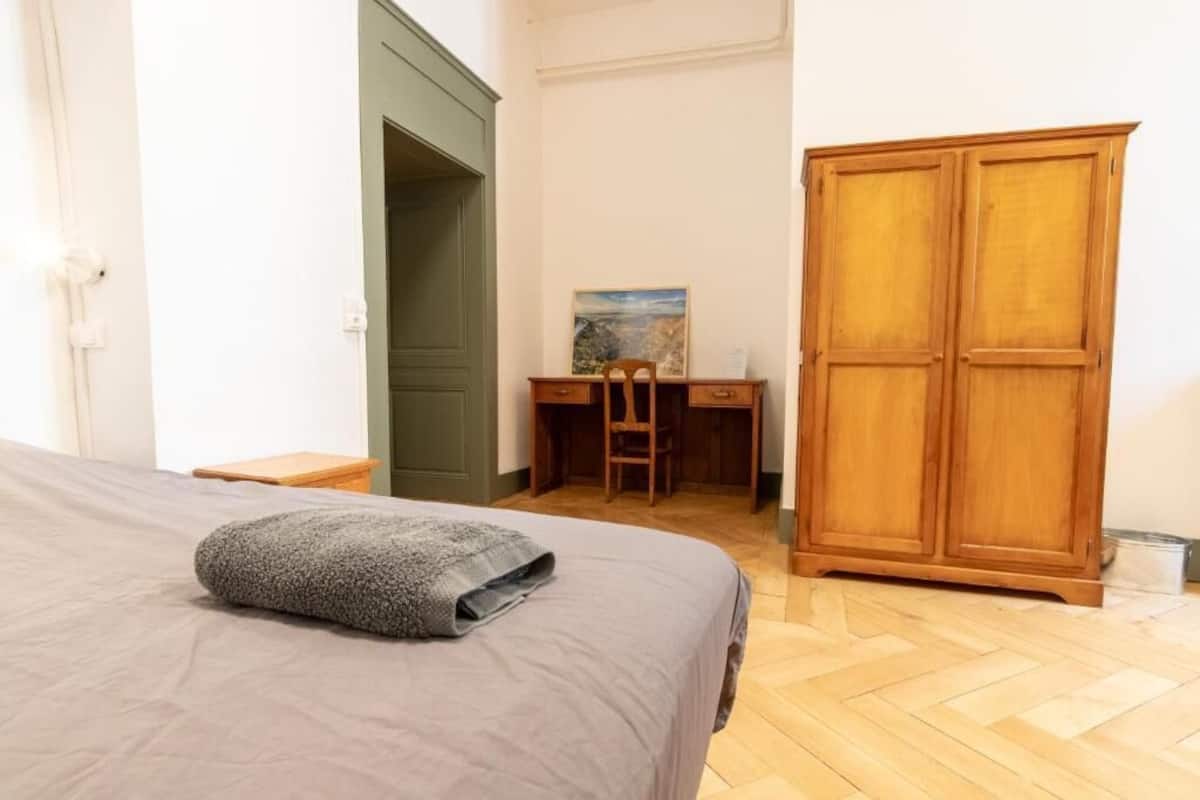 Une chambre à coucher avec un lit, un bureau et une armoire.