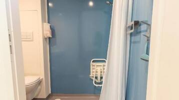 A bathroom with a shower, toilet, and a towel rack.