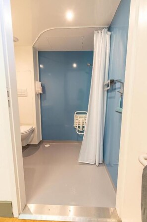 Ein Badezimmer mit Dusche, Toilette und Handtuchhalter.