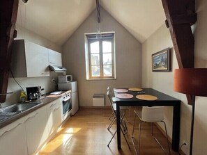 Eine kleine Küche mit Essbereich, einem Fenster und einem Bild an der Wand.