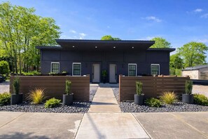 A modern two-story house with a flat roof, a central entrance, and a symmetrical design.