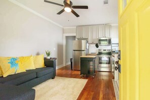 A modern kitchen with stainless steel appliances, a ceiling fan, and a yellow door. - Civil Rights Trail Townhome - Near Historic Sites (Montgomery)