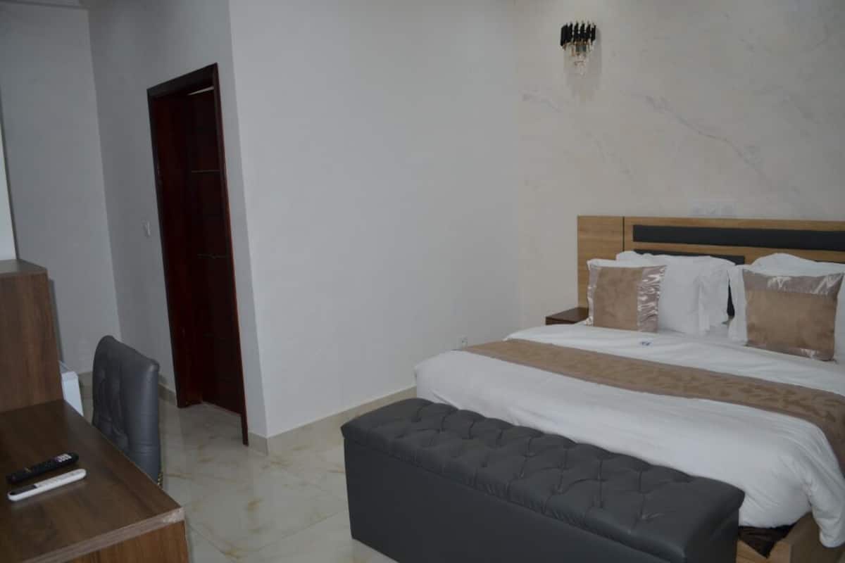 A bedroom with a bed, bedside tables, a desk, and a chair.