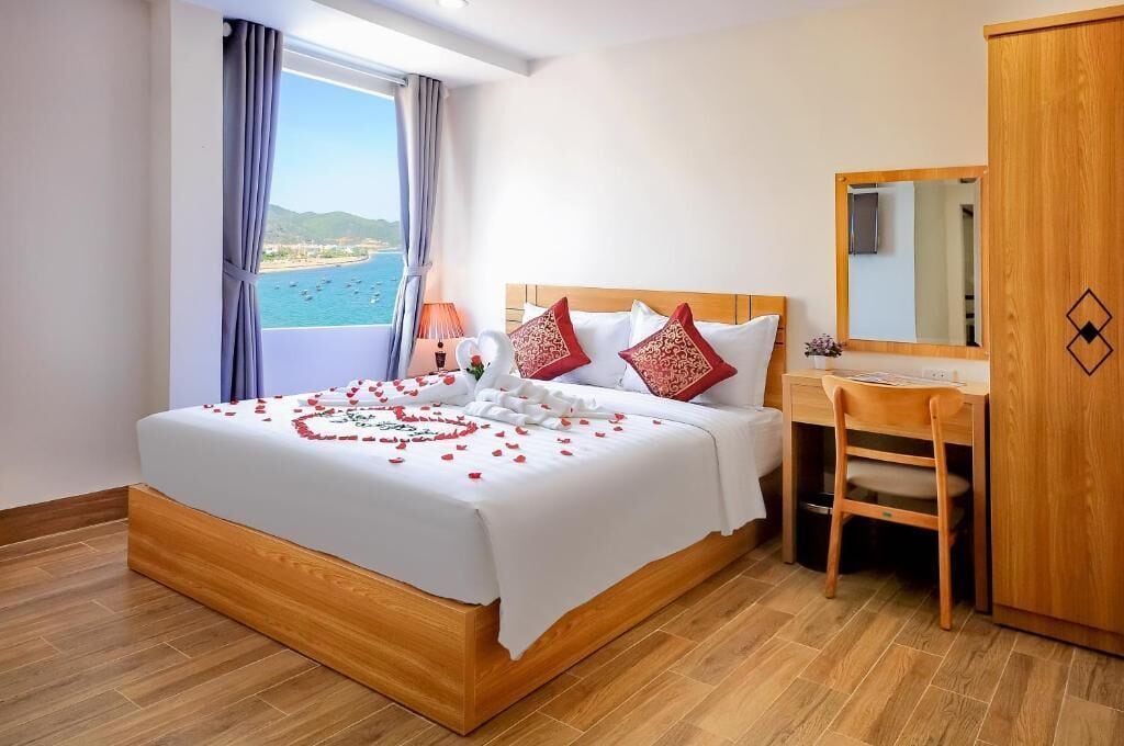 A hotel room with a bed, a desk, and a wardrobe.