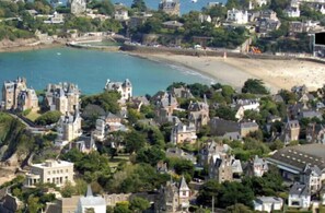 A coastal town with historic buildings, a beach, and a harbor. - Studio Cosy Mer & Bus St-Malo (Dinard)