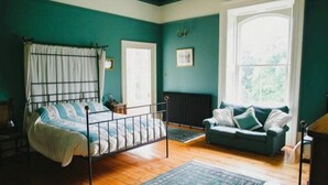 A room with a bed, a sofa, a radiator, and a window. - Ballynacree Manor House  (Ballymoney)