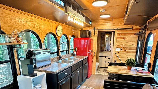 Cocina compacta con microondas, pileta y refrigerador rojo.