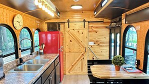 Una cocina compacta con un lavabo, estufa y un refrigerador rojo.