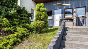 A staircase leading to a building with a modern design, surrounded by greenery and a clear sky. - Studio Apartment with Mountain View, Private Terrace and Wi-Fi (Ruhla)