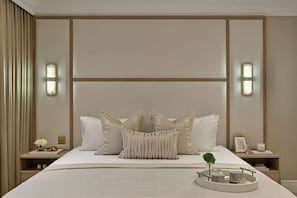Ein ordentlich eingerichtetes Hotelzimmer mit einem großen Bett, zwei Nachttischen und einem Tablett mit Dekorationselementen.